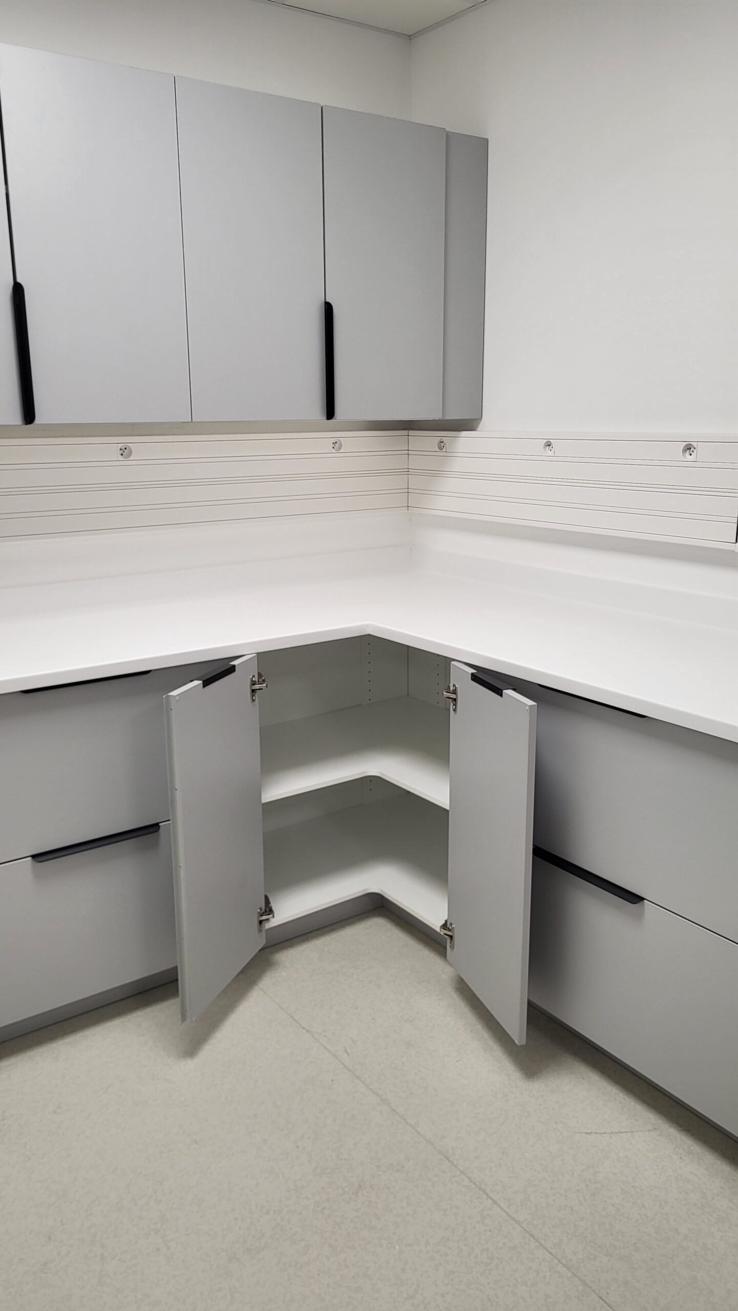 Rangements d’angle ouverts et plan de travail d’une salle de soins sur mesure
